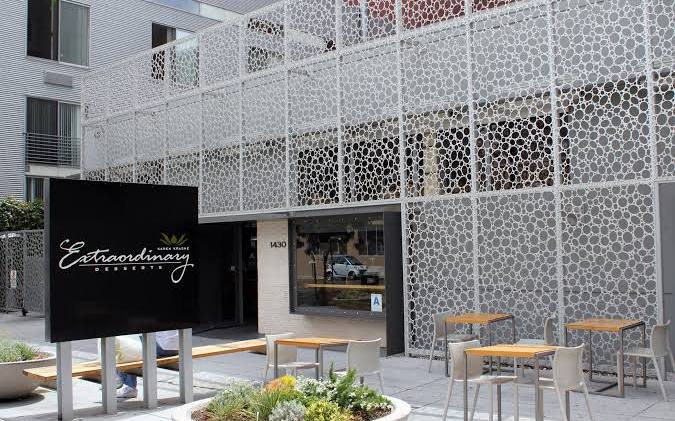 The perforated white facade and sign of Extraordinary Desserts