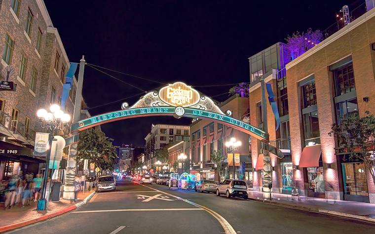 The lit Gaslamp Quarter arch over Fifth Avenue at night